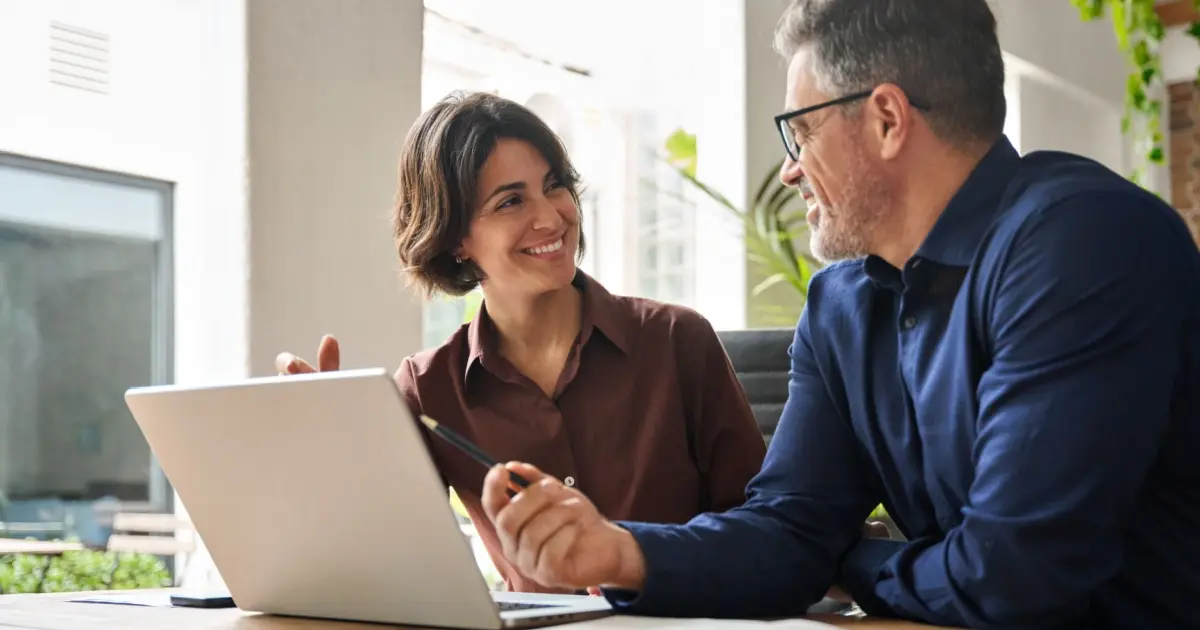 Insurance agent consulting with client on laptop