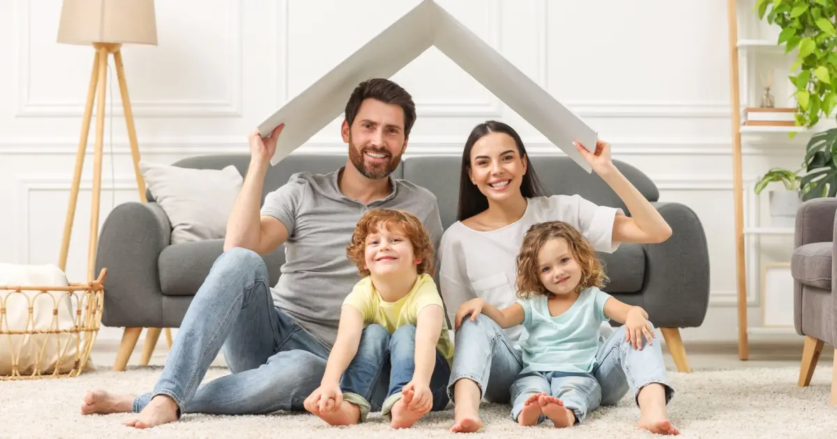 Family sitting under roof shape for home insurance concept